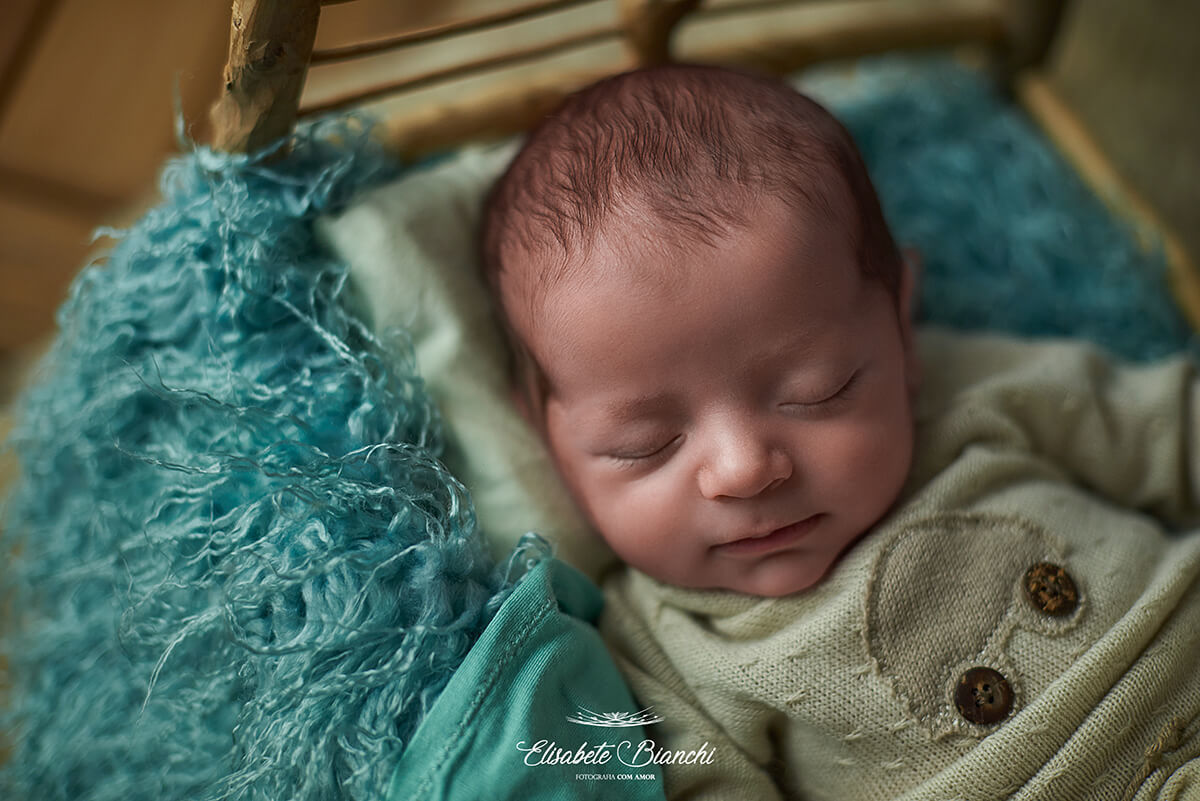 Close em recém-nascido dormindo na caminha, no ensaio newborn, em Caxias do Sul.