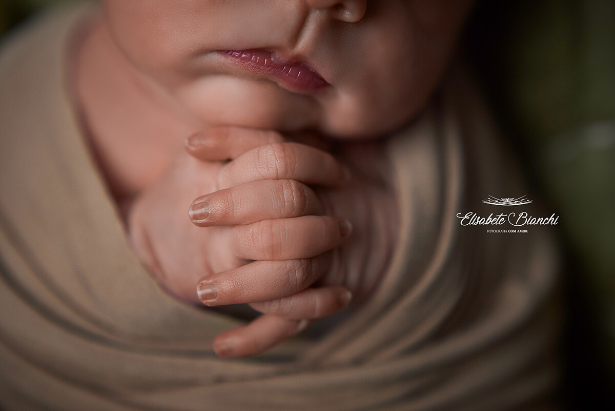 Detalhe de mãos em oração de uma bebê recém-nascida, em ensaio newborn em Caxias do Sul.