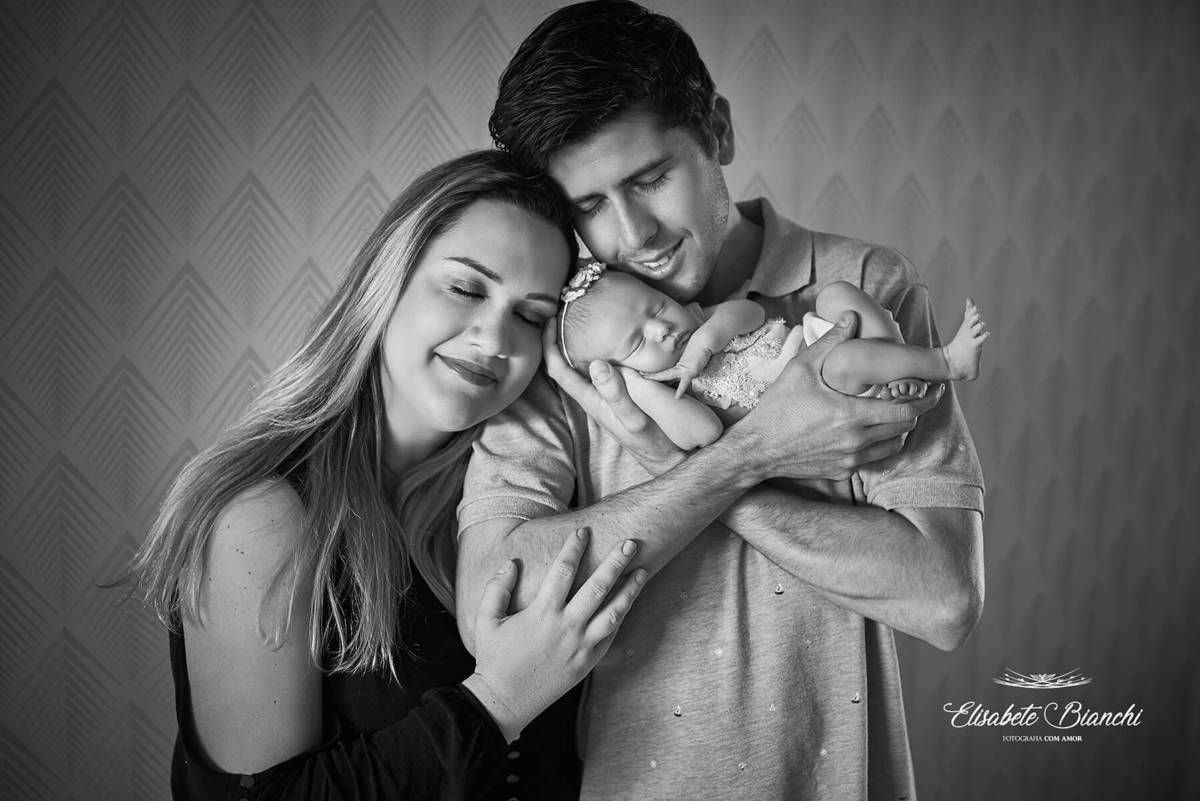 Pais com sua bebê recém-nascida, em ensaio newborn em Caxias do Sul-RS. Foto preto e branco.