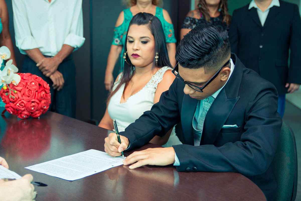 noivo assinando papeis do casamento