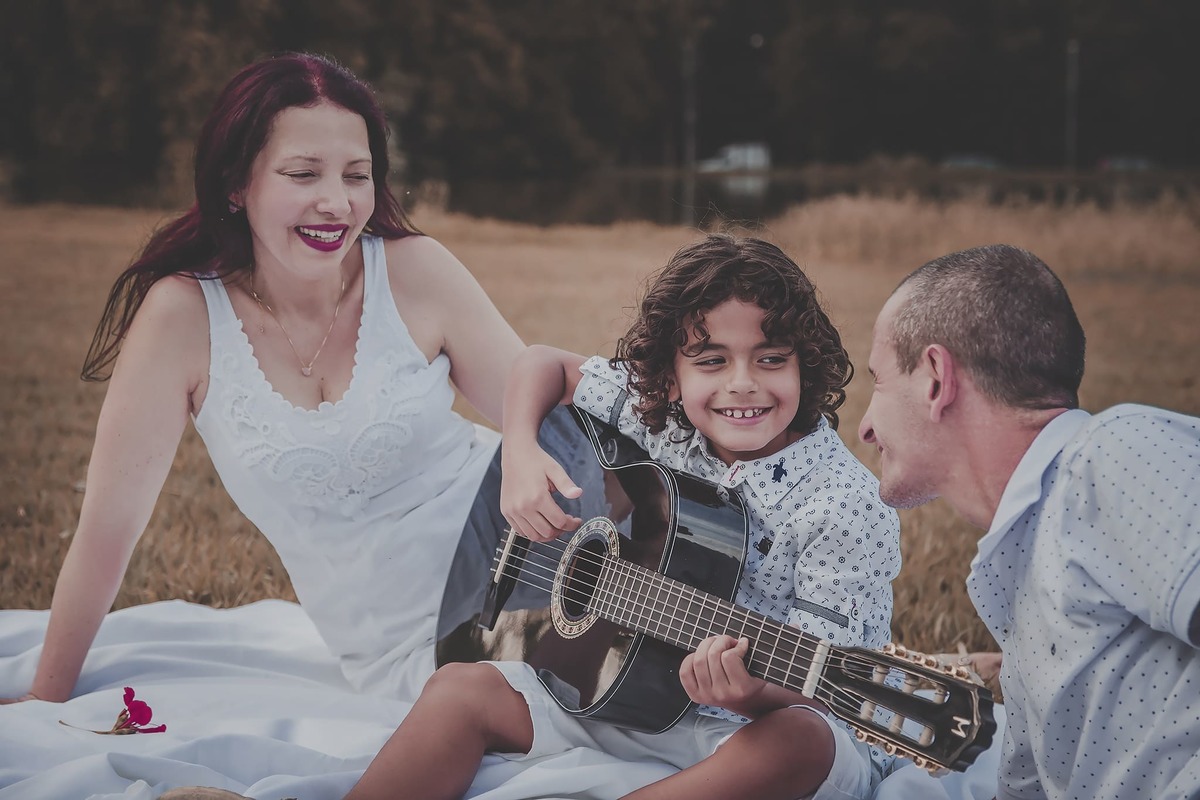 tocando violão no parque com os pais
