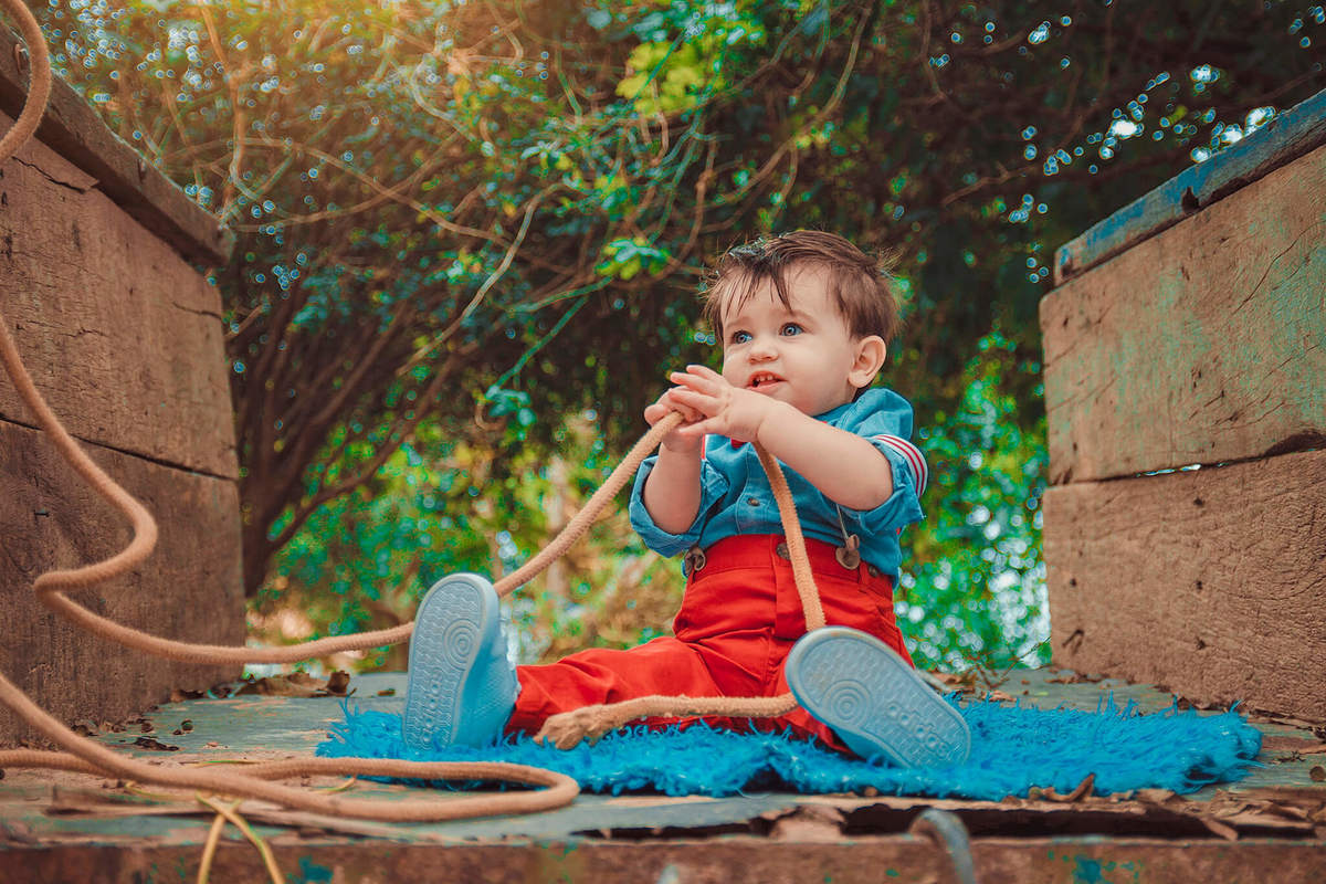 bebê sentado brincando com corda