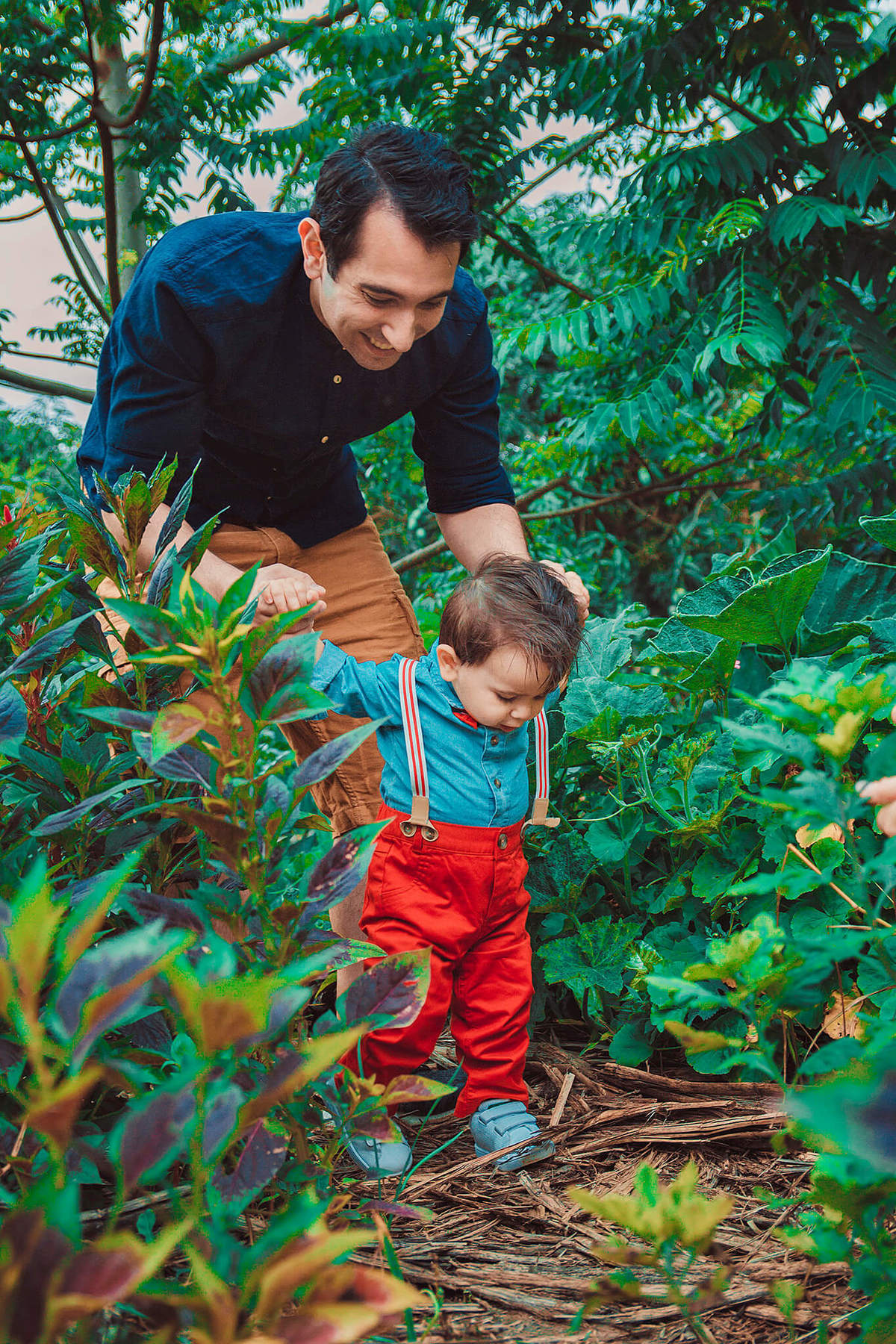 bebê caminhando com o papai segurando