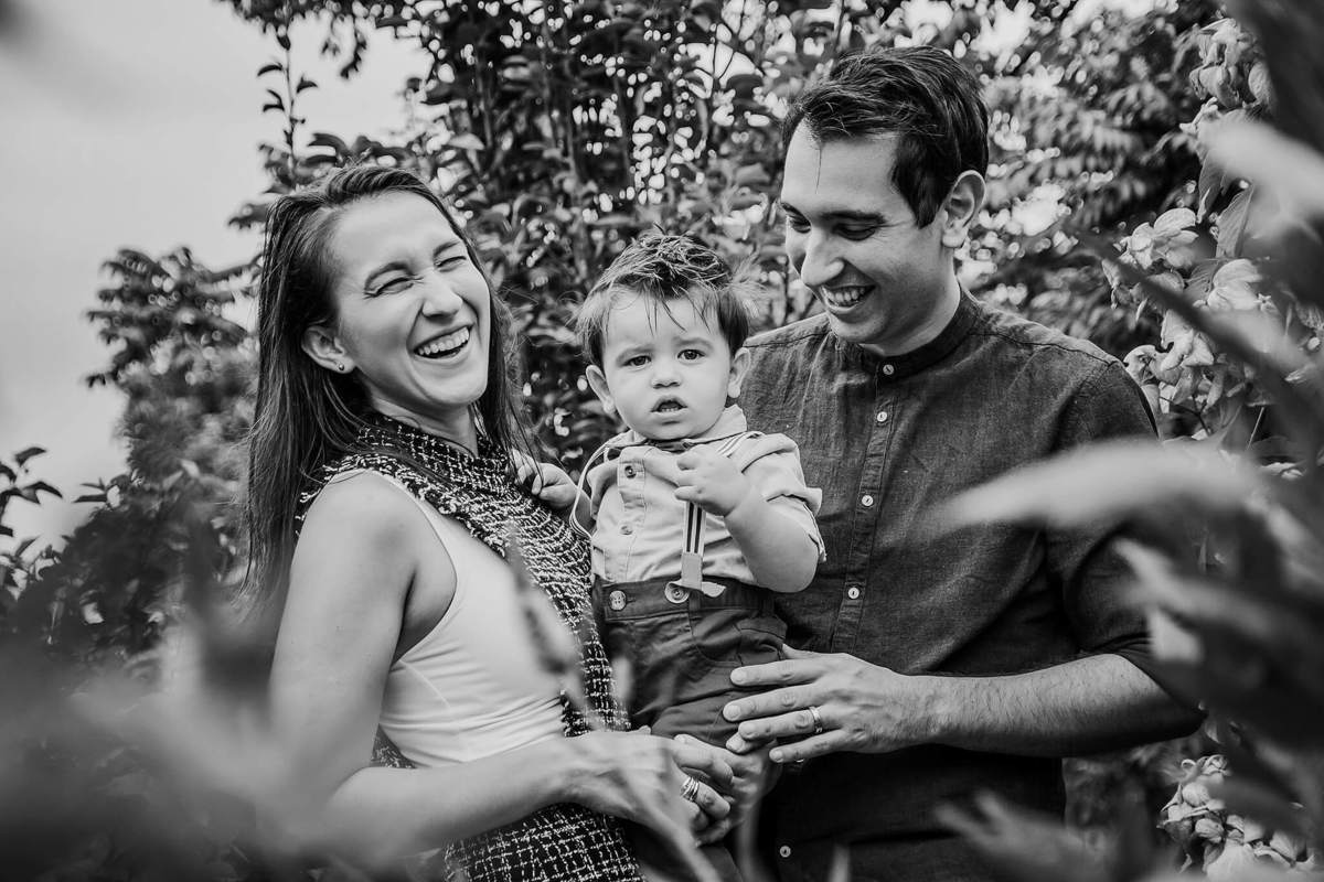 papai e mamãe felizes com filho no colo