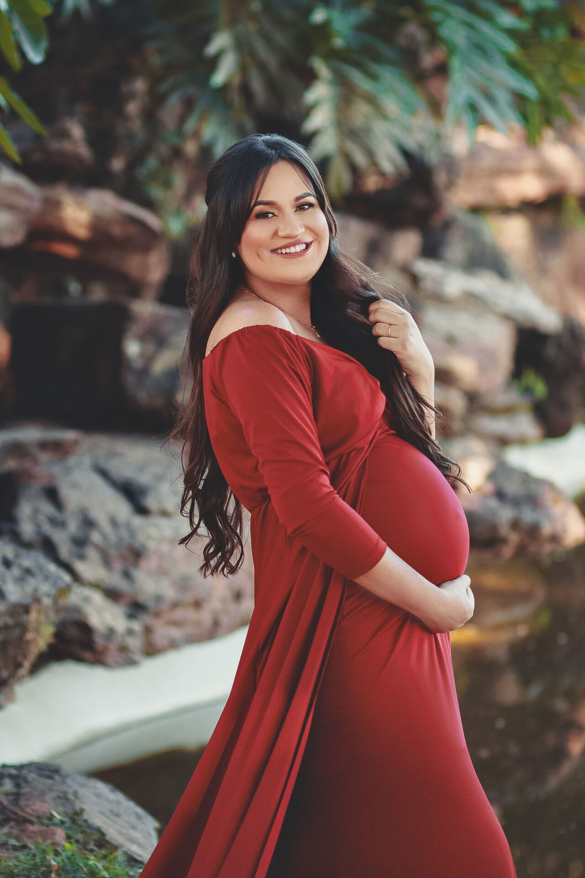 gestante sorrindo com as mãos no cabelo,  em holambra - sp