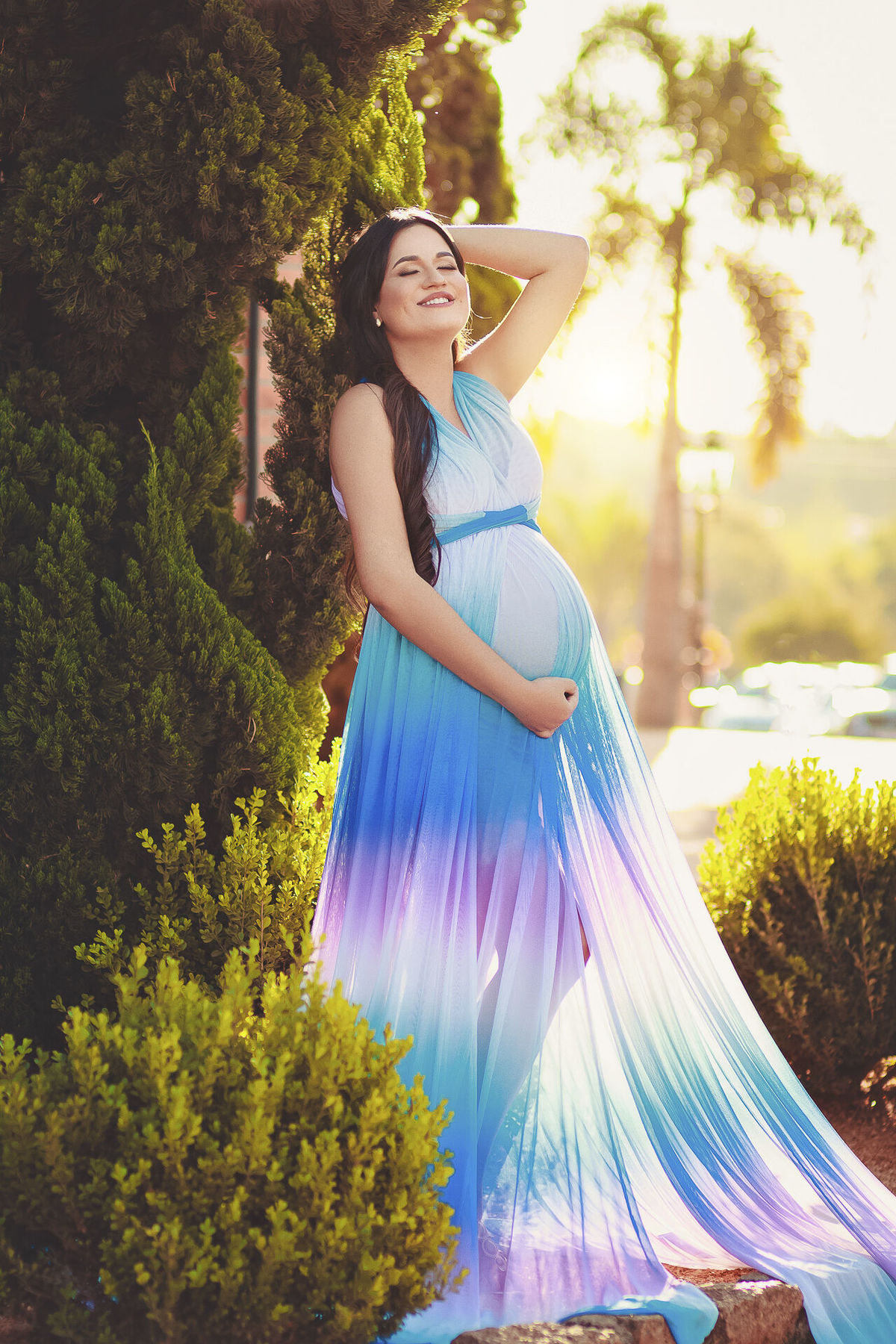 Gestante com vestido arco iris e maos na cabeça,  em holambra - sp
