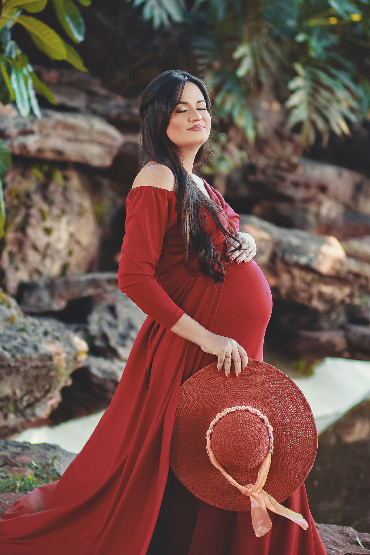 Gestante segurando chapéu e mão na barriga,  em holambra - sp