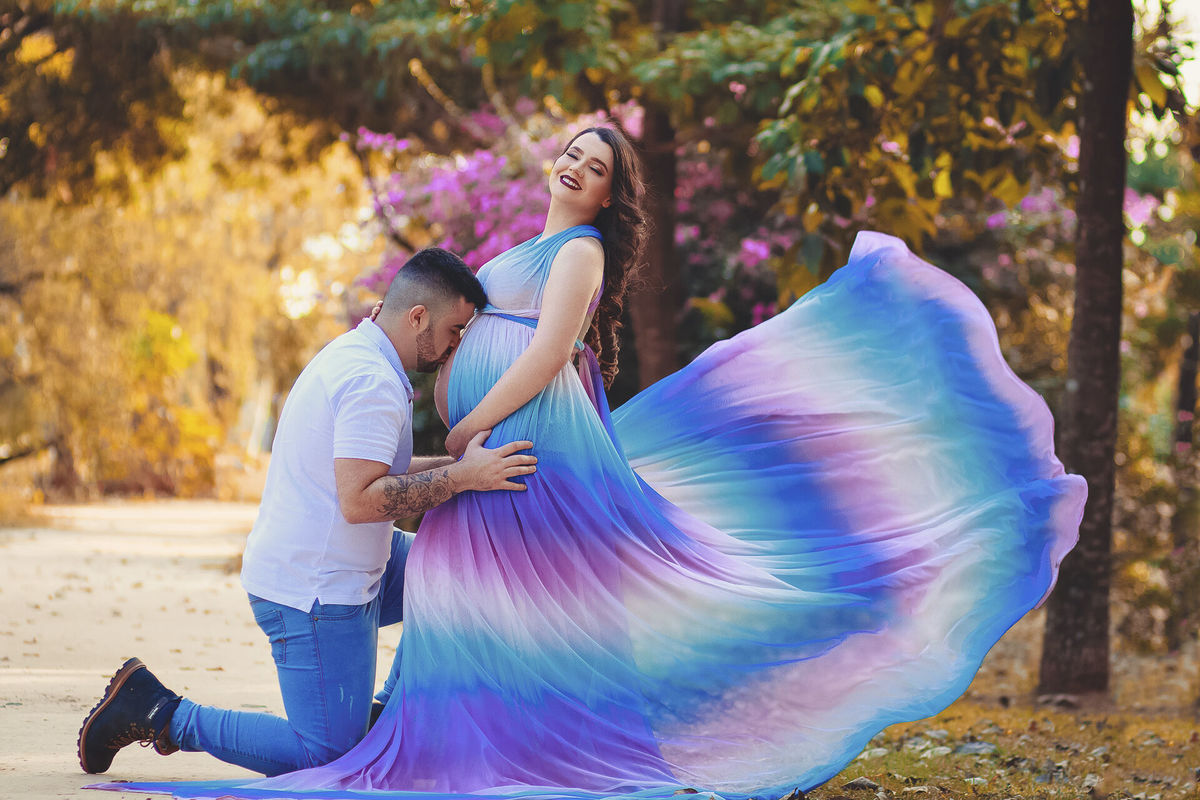linda gestante com vestido arco iris no parque dos ipes, em santa barbara doeste - sp, fazendo ensaio gestante