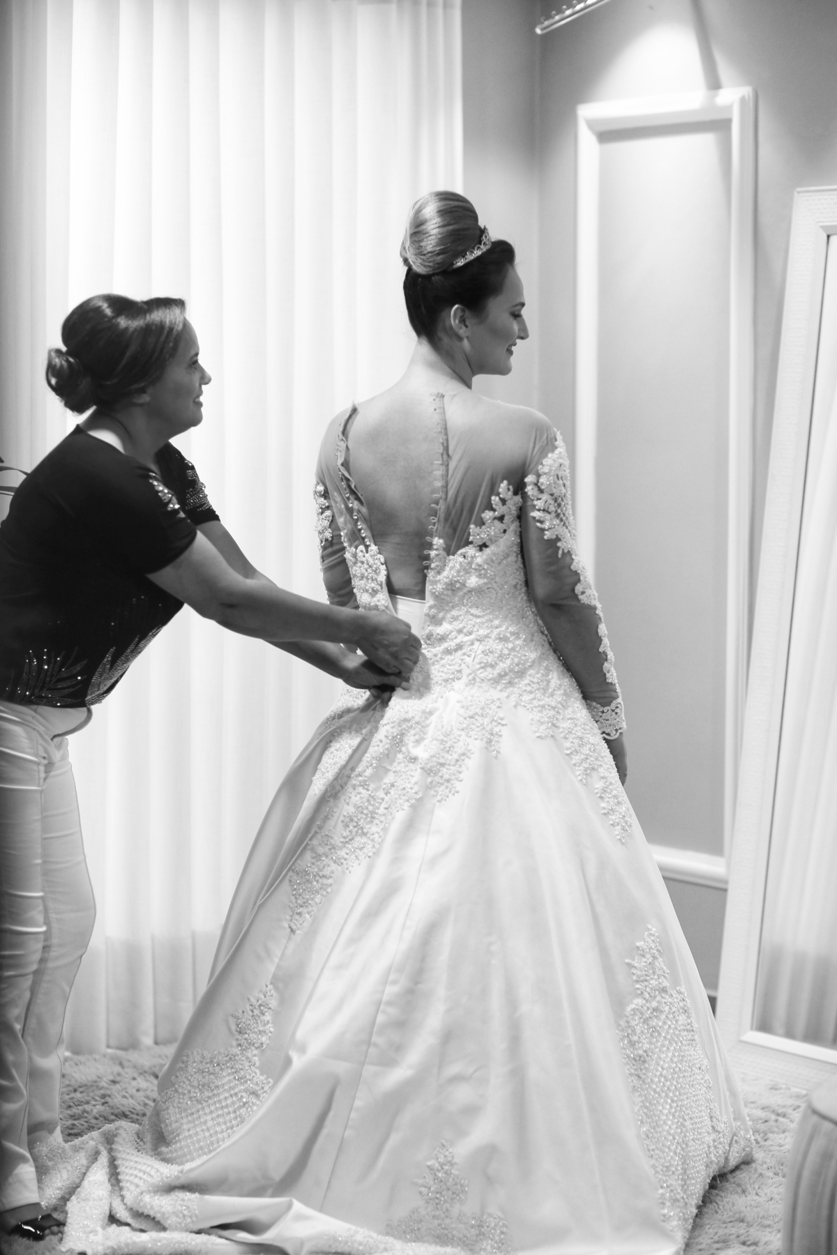 mãe vestindo a noiva no dia do casamento