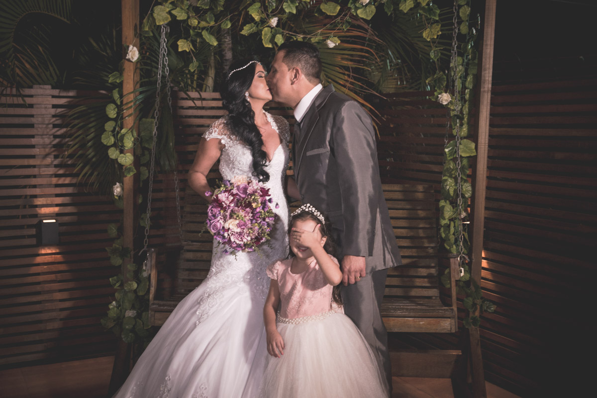 fotografo fabio doria registra casal de beijando com dama de olhos vendados em pergolado com balanço casa de festas joshua campo grande