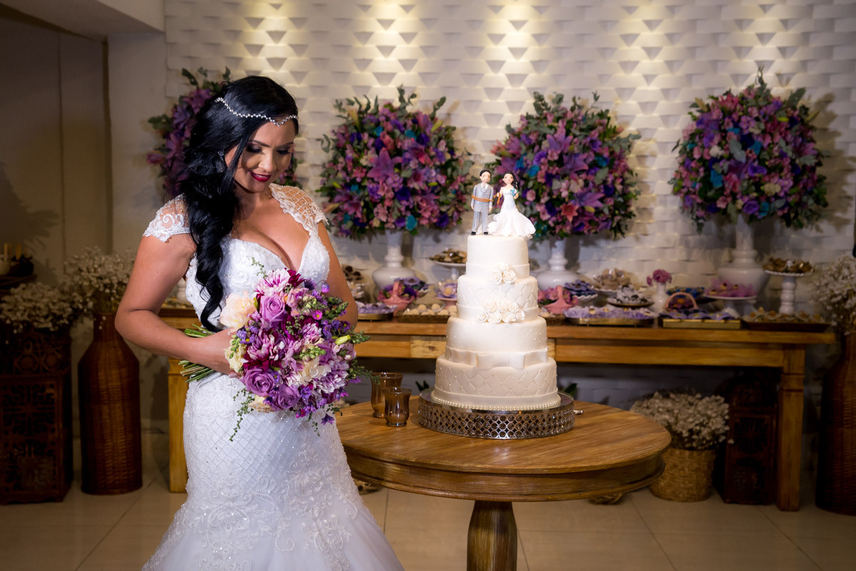 noiva olha para buque na mesa do bolo fotografo fabio doria