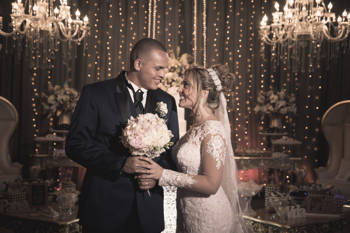 noivo segurando o buquê e noiva olhando