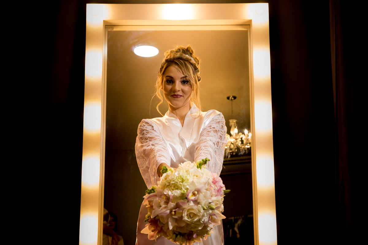 noiva de roupão mostrando o buquê