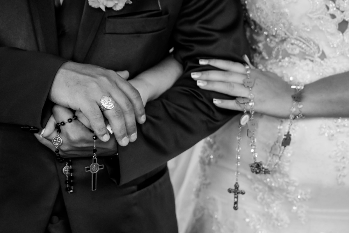 noiva segurando terço com o noivo no altar