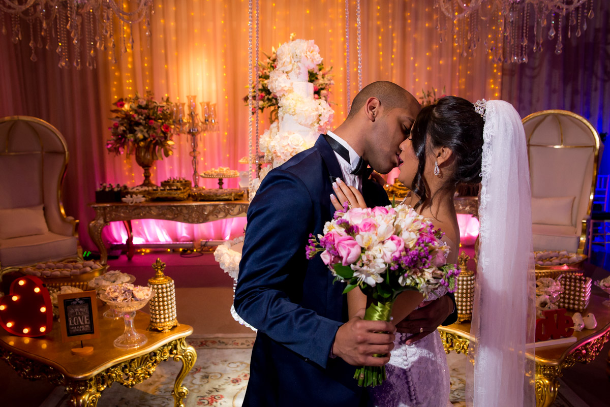 noivos se beijando na mesa do bolo