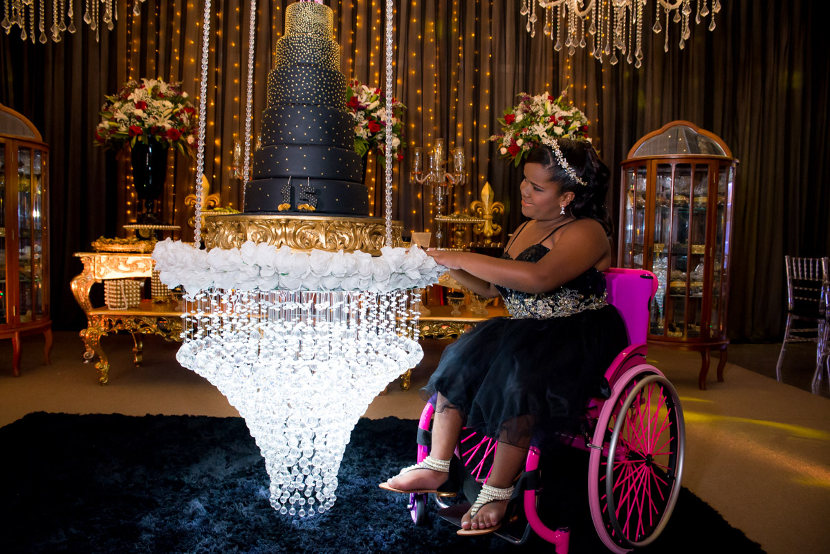 menina cadeirante apoiada na mesa do bolo