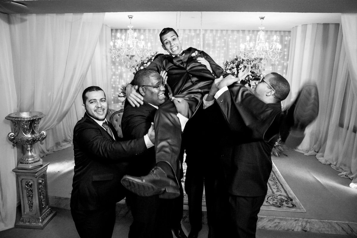 padrinhos segurando noivo 