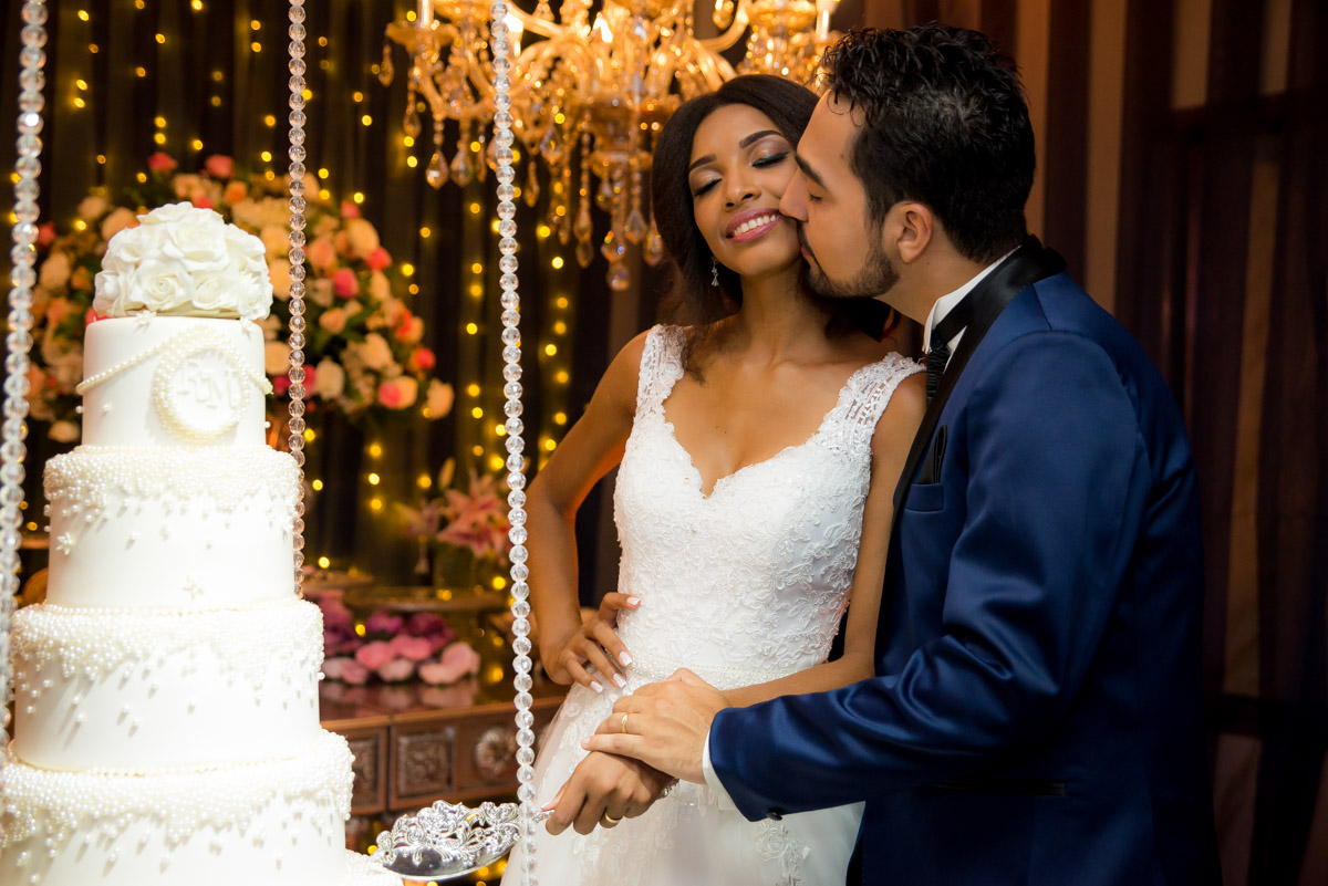 noivos na mesa cortando o bolo 