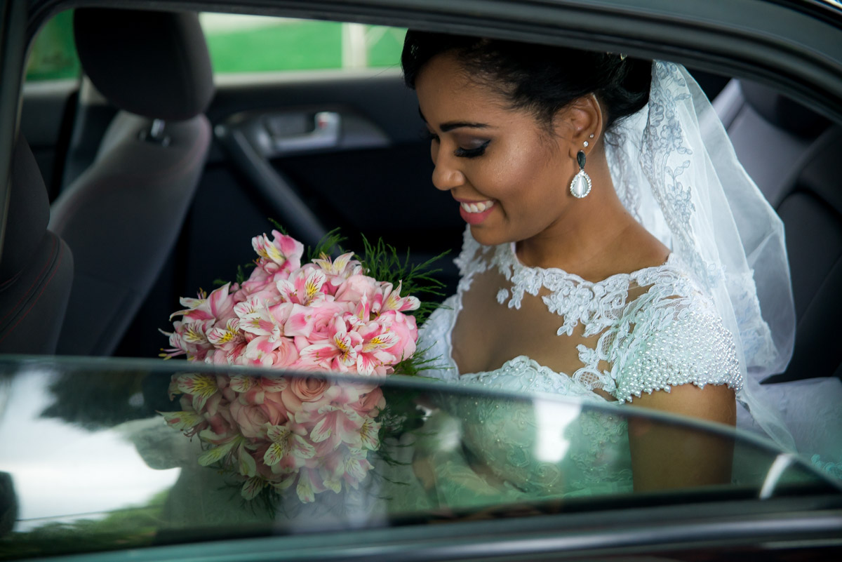 noiva dentro do carro olhando para o buquê 