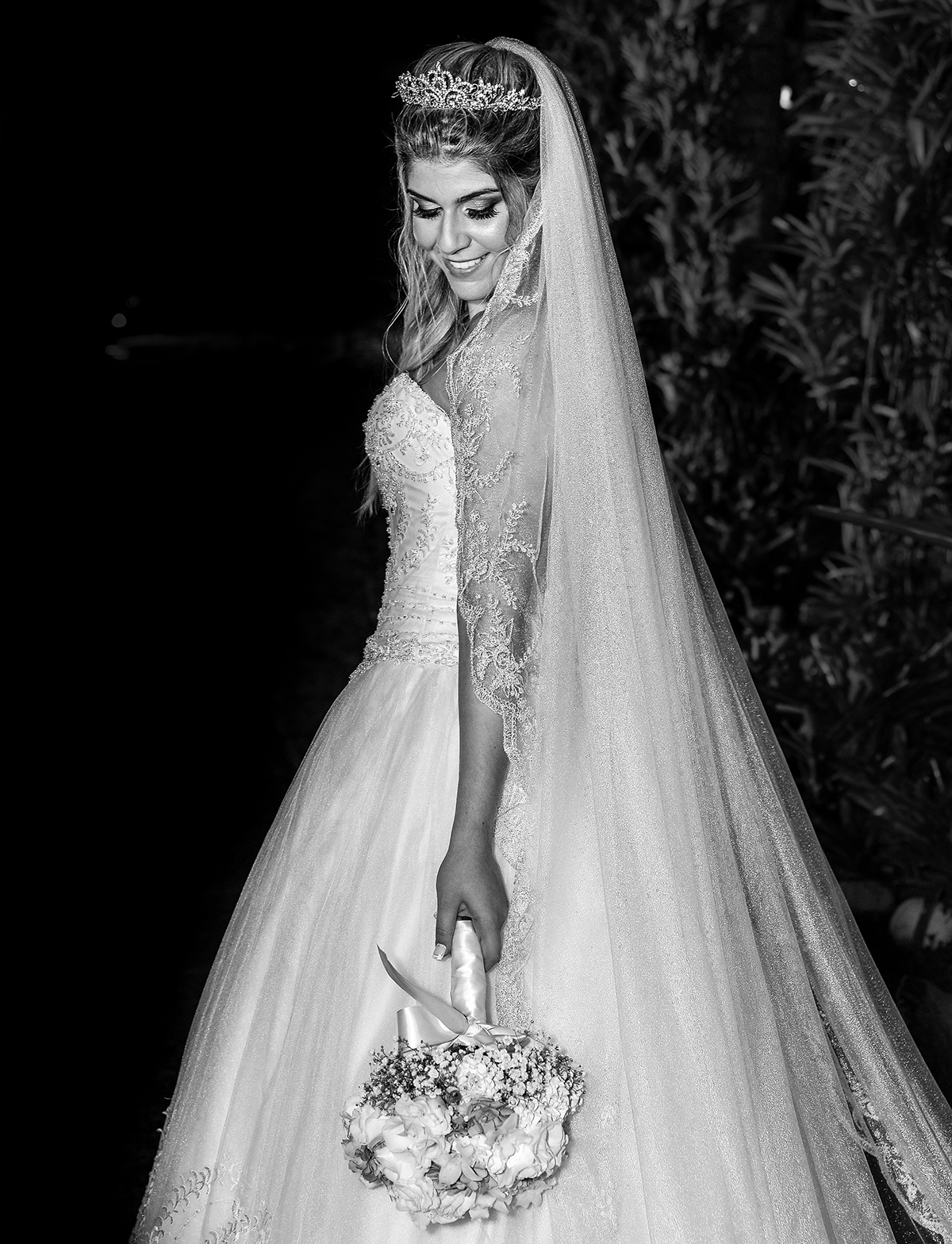 noiva segurando e olhando para o buque