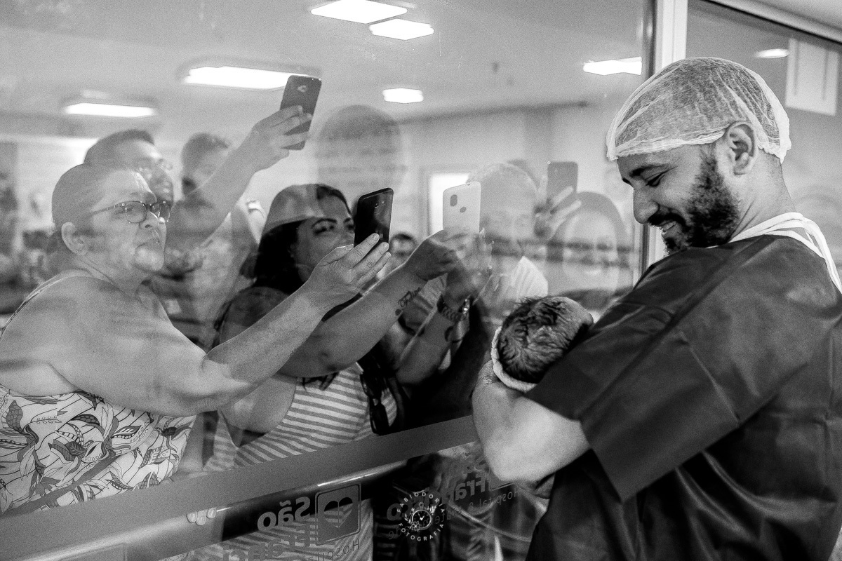 Maternidade São Francisco Niterói a chegada de Emanuel Fotógrafo de parto Fabio Doria o melhor do rio de janeiro e niterói sala de cirurgia de parto pai segura filho pela primeira vez