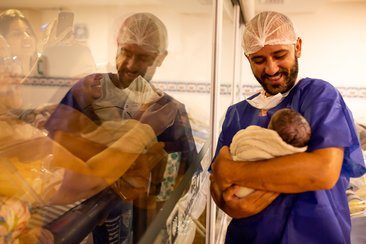 Maternidade São Francisco Niterói a chegada de Emanuel Fotógrafo de parto Fabio Doria o melhor do rio de janeiro e niterói sala de cirurgia de parto pai segura filho pela primeira vez