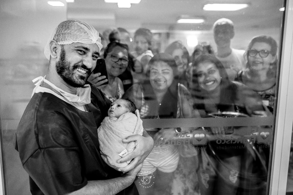 Maternidade São Francisco Niterói a chegada de Emanuel Fotógrafo de parto Fabio Doria o melhor do rio de janeiro e niterói sala de cirurgia de parto pai segura filho pela primeira vez