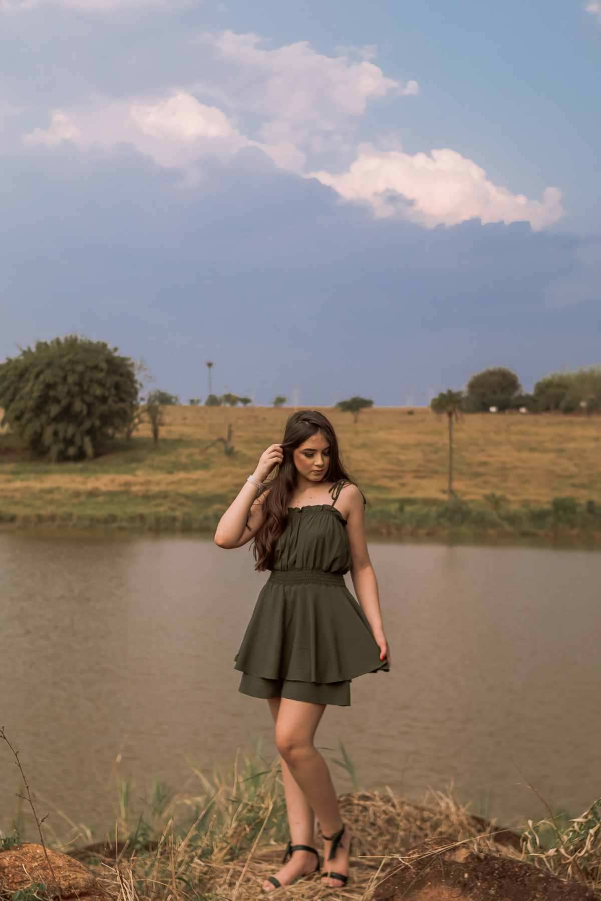 Ensaio de 15 anos em Ribeirão Preto com luz natural – Ana Júlia em meio à natureza, vestindo roupa clara, com expressão serena e olhar suave, refletindo a delicadeza e autenticidade dessa fase especial.