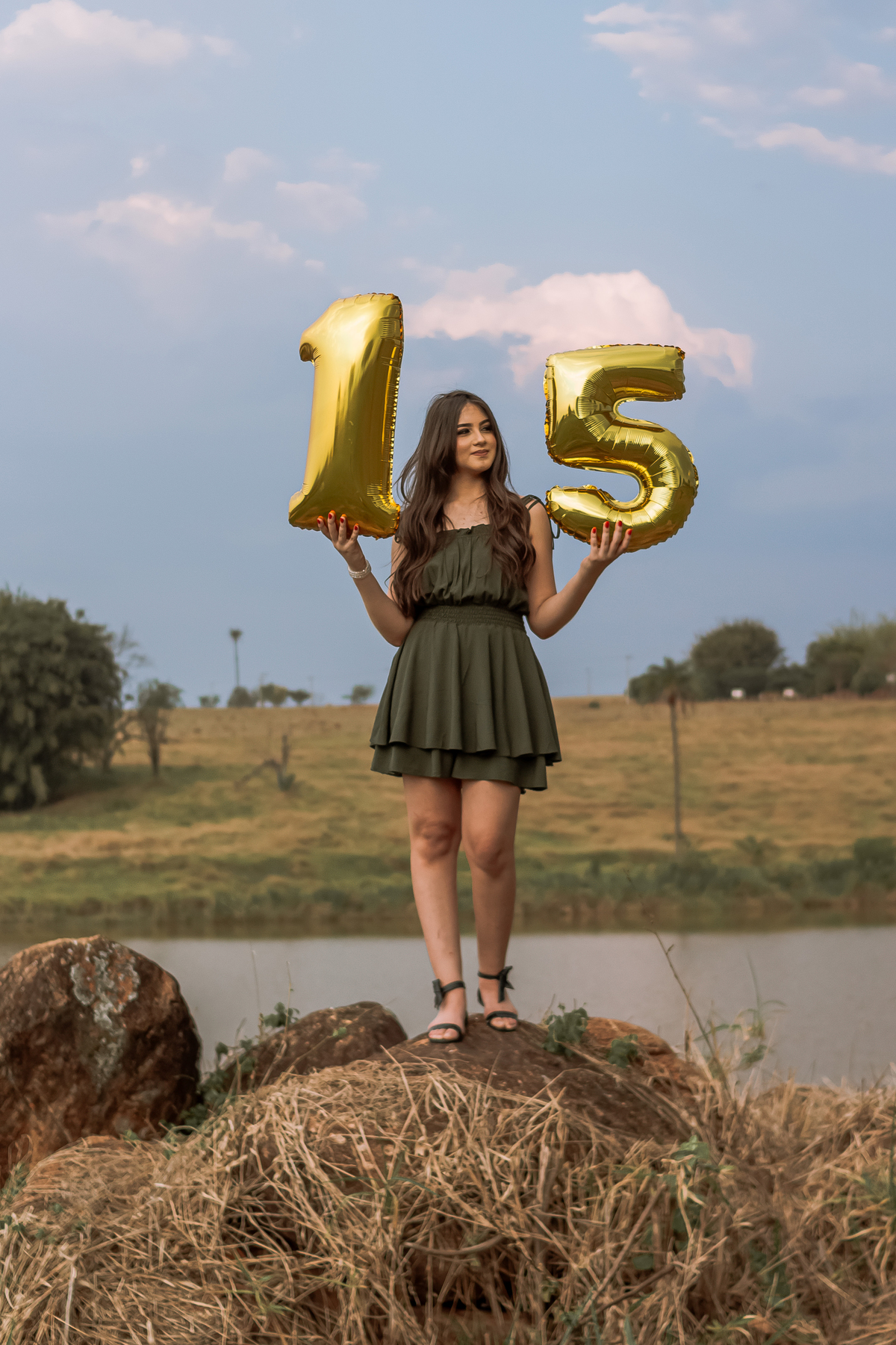 Ensaio de 15 anos em Ribeirão Preto com luz natural – Ana Júlia em meio à natureza, vestindo roupa clara, com expressão serena e olhar suave, refletindo a delicadeza e autenticidade dessa fase especial.