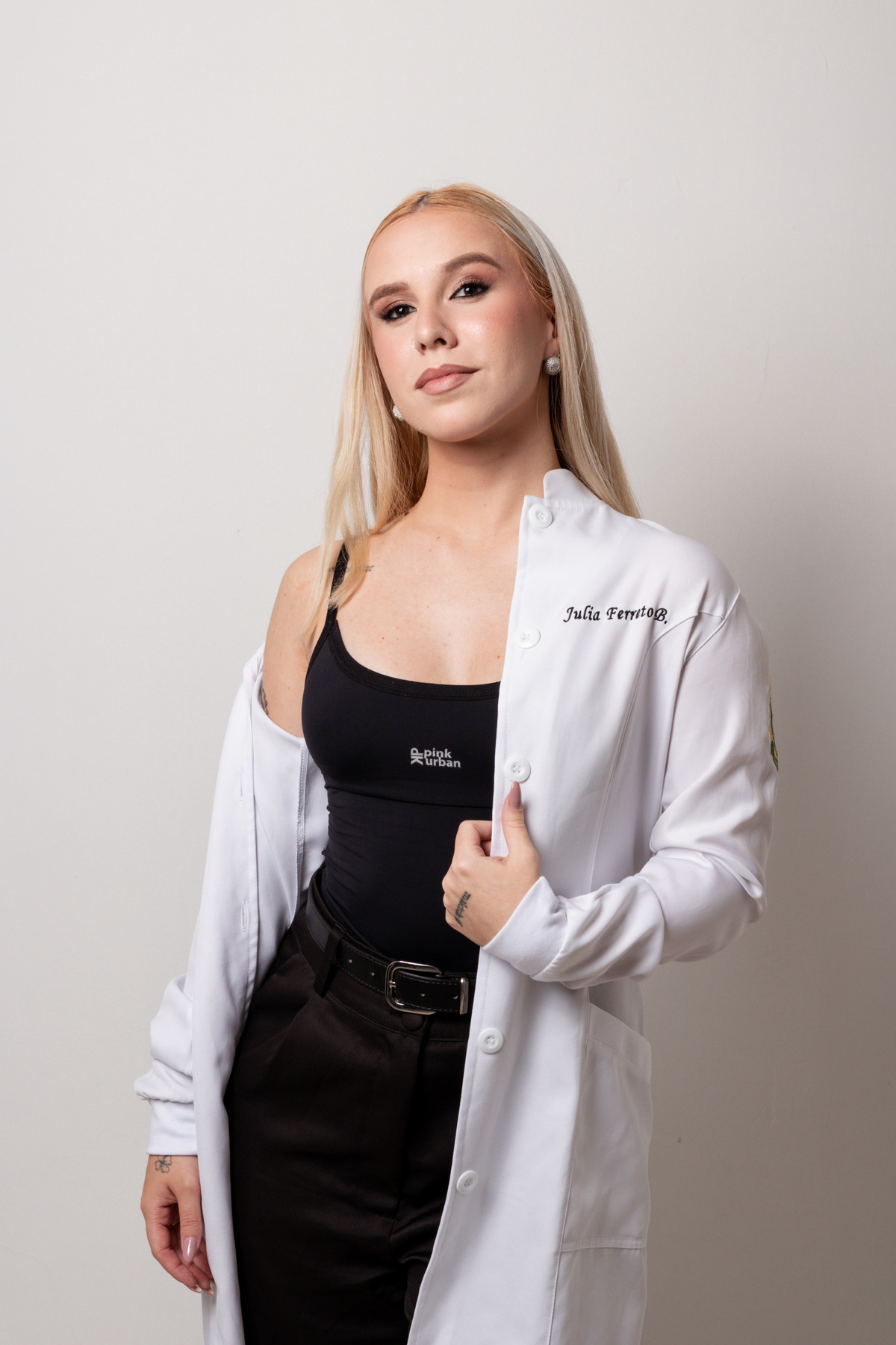 Ensaio fotográfico profissional de nutricionista esportiva em estúdio em Ribeirão Preto. Retratos corporativos femininos com jaleco e foco em posicionamento de imagem e autoridade.