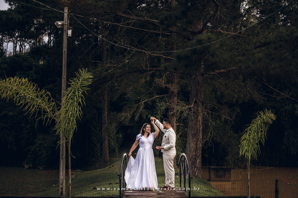 Ensaio de casal no campo com vestido de noiva