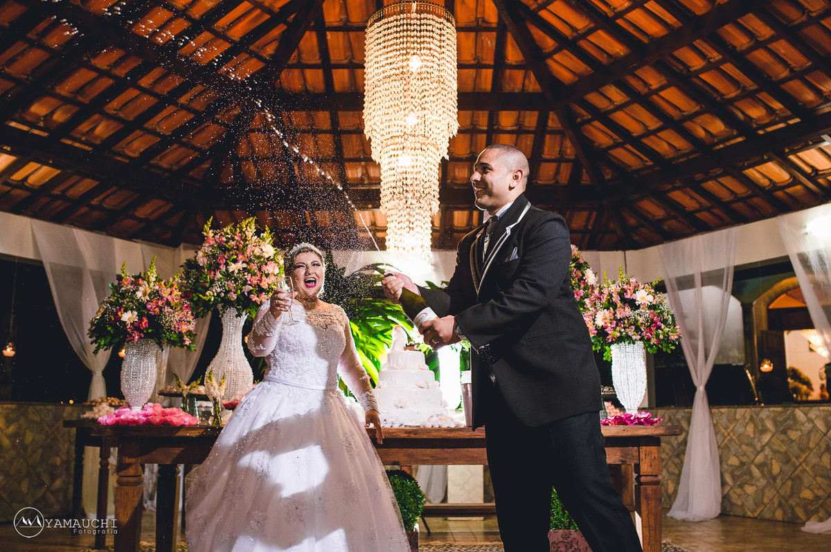 Noivos estourando champanhe