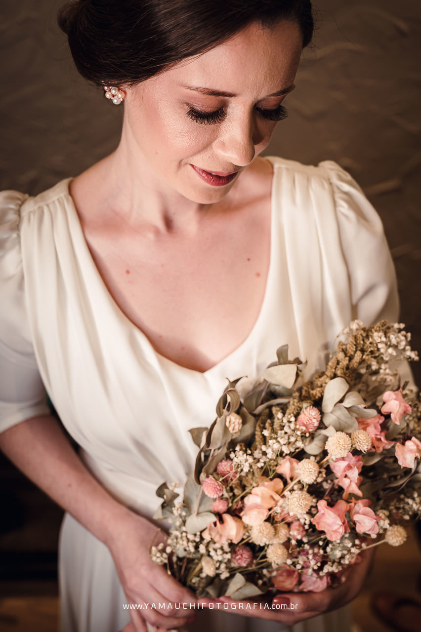 Vestido de noiva para casamento no campo e buque de flores