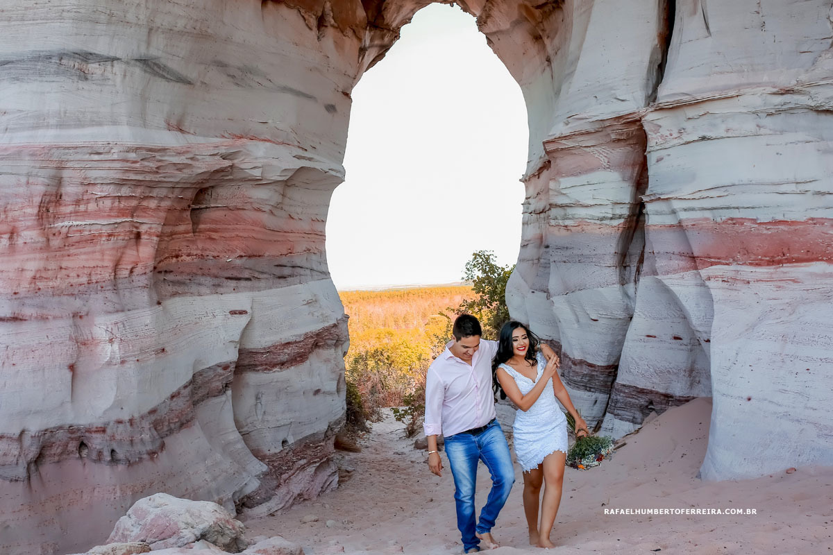 casal caminhando na pedra furada no ensaio pre casamento