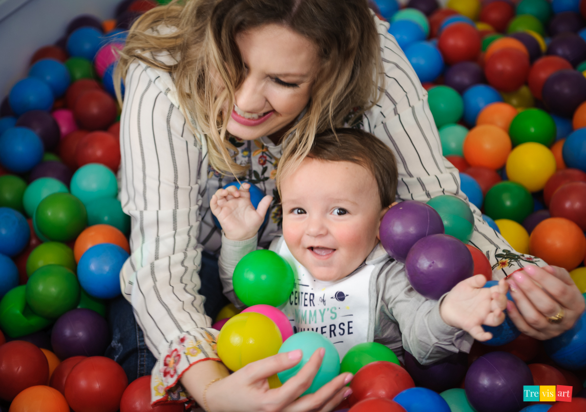 Aniversariante brincando com sua madrinha na piscina de bolinhas do buffet, tema de festa infantil madagascar