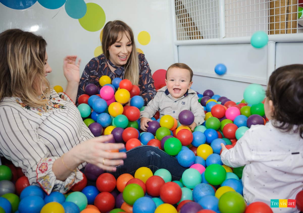 Aniversariante brincando com sua mãe, sua madrinha e amigo na piscina de bolinhas do buffet, tema de festa infantil madagascar