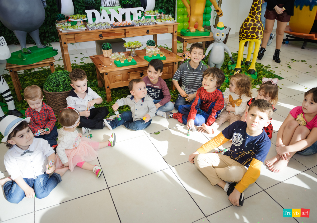 Crianças fazendo foto na decoração do tema madagascar, na mesa da decoração, em buffet infantil