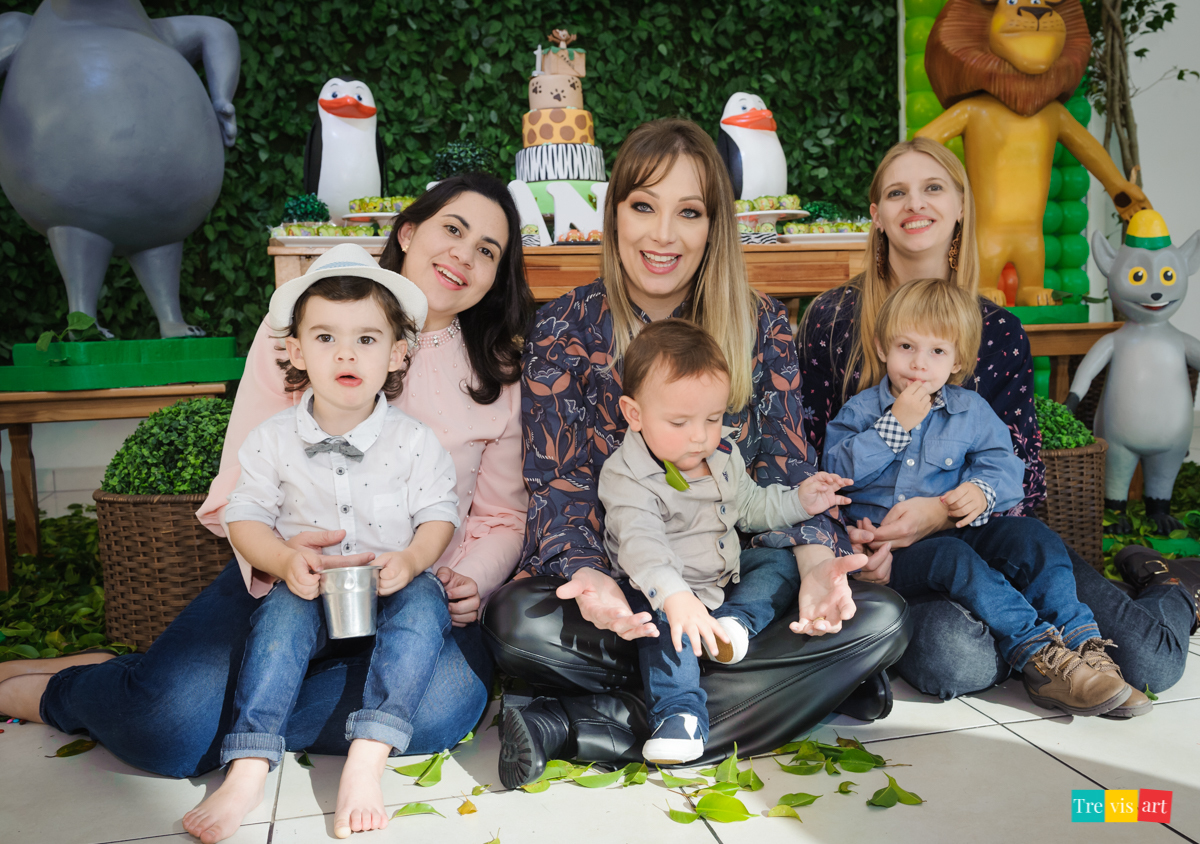 Crianças e mães fazendo foto na decoração do tema madagascar, na mesa da decoração, em buffet infantil