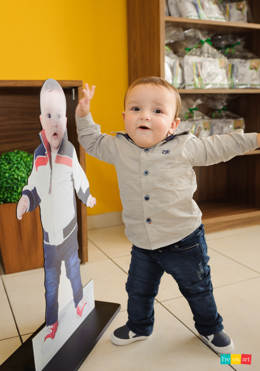 Aniversariante sorrindo com totem de foto na entrada da festa infantil, tema madagascar