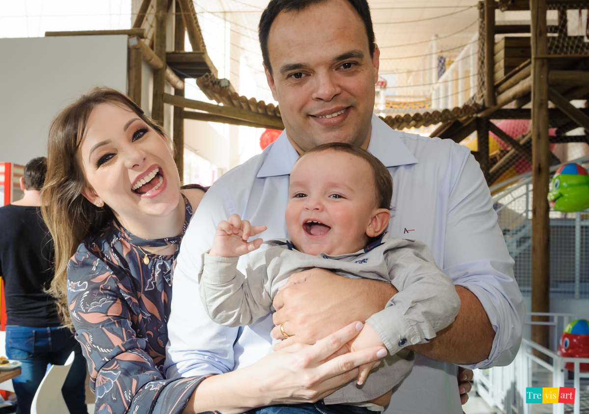 Família sorrindo para foto na festa infantil, festa de menino, tema madagascar