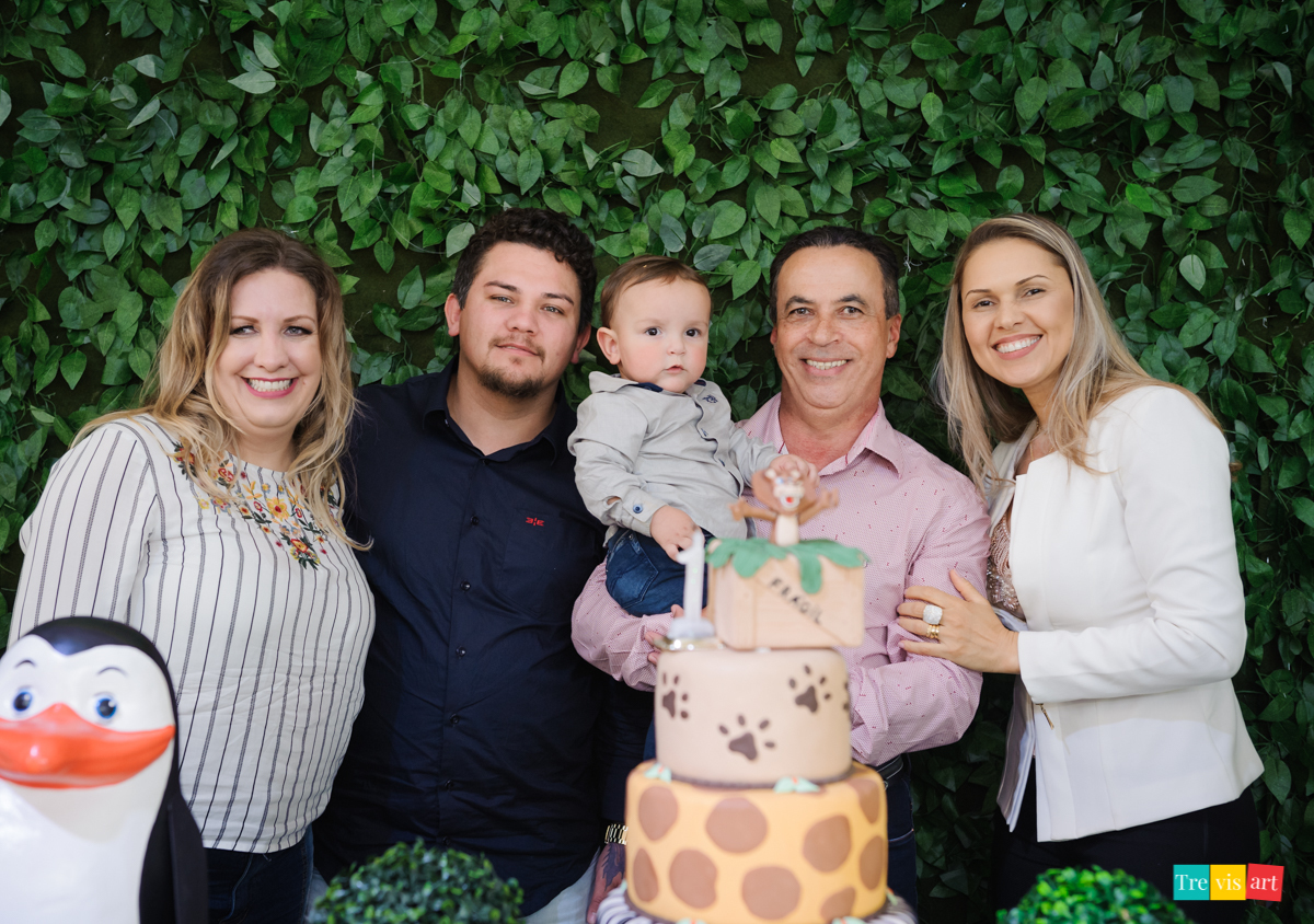 Madrinha, padrinhos e aniversariante fazendo foto na mesa da decoração, tema de festa infantil de menino madagascar