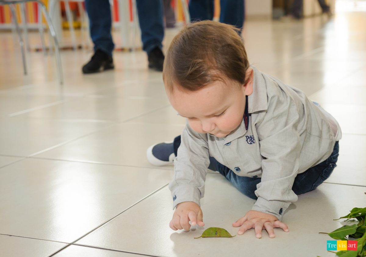 Aniversariante brincando em frente a mesa da decoração tema de festa infantil madagascar