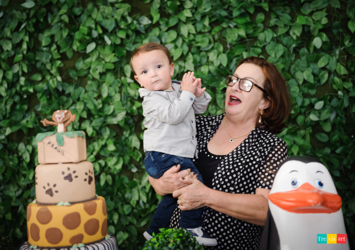 Vovó e aniversariante fazendo foto na mesa da decoração, tema de festa infantil de menino madagascar