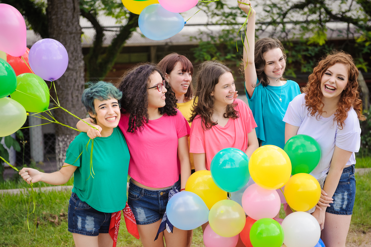 Meninas com balões coloridos e posando para foto de book de 15 anos