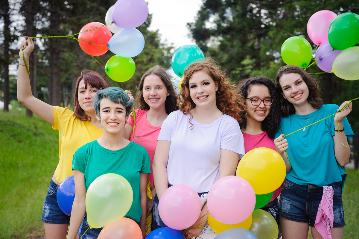 Meninas posando para foto com balões coloridos e posando para foto de book de 15 anos