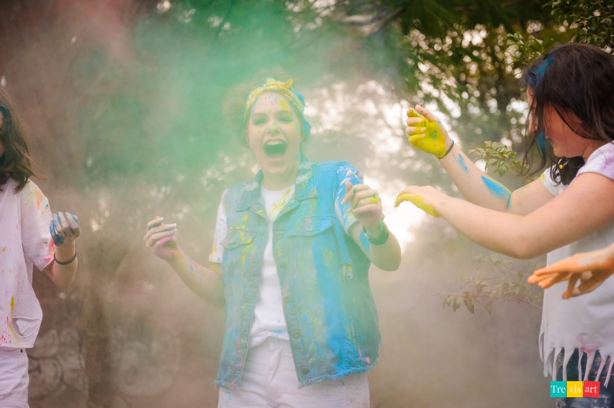 Meninas de branco jogando pó de happy holi azul  para foto de book de 15 anos da amiga