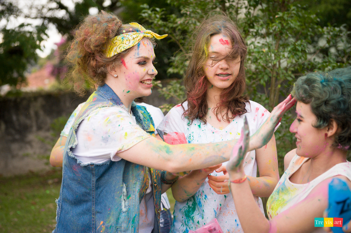 Meninas brincando com pó de happy holi colorido para foto de book de 15 anos da amiga