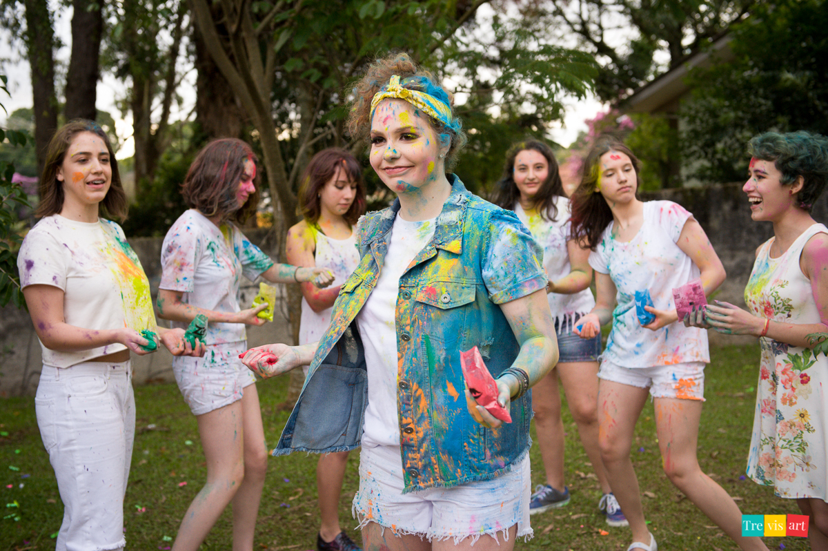 Meninas brincando com pó de happy holi colorido para fotografia de book de 15 anos da amiga