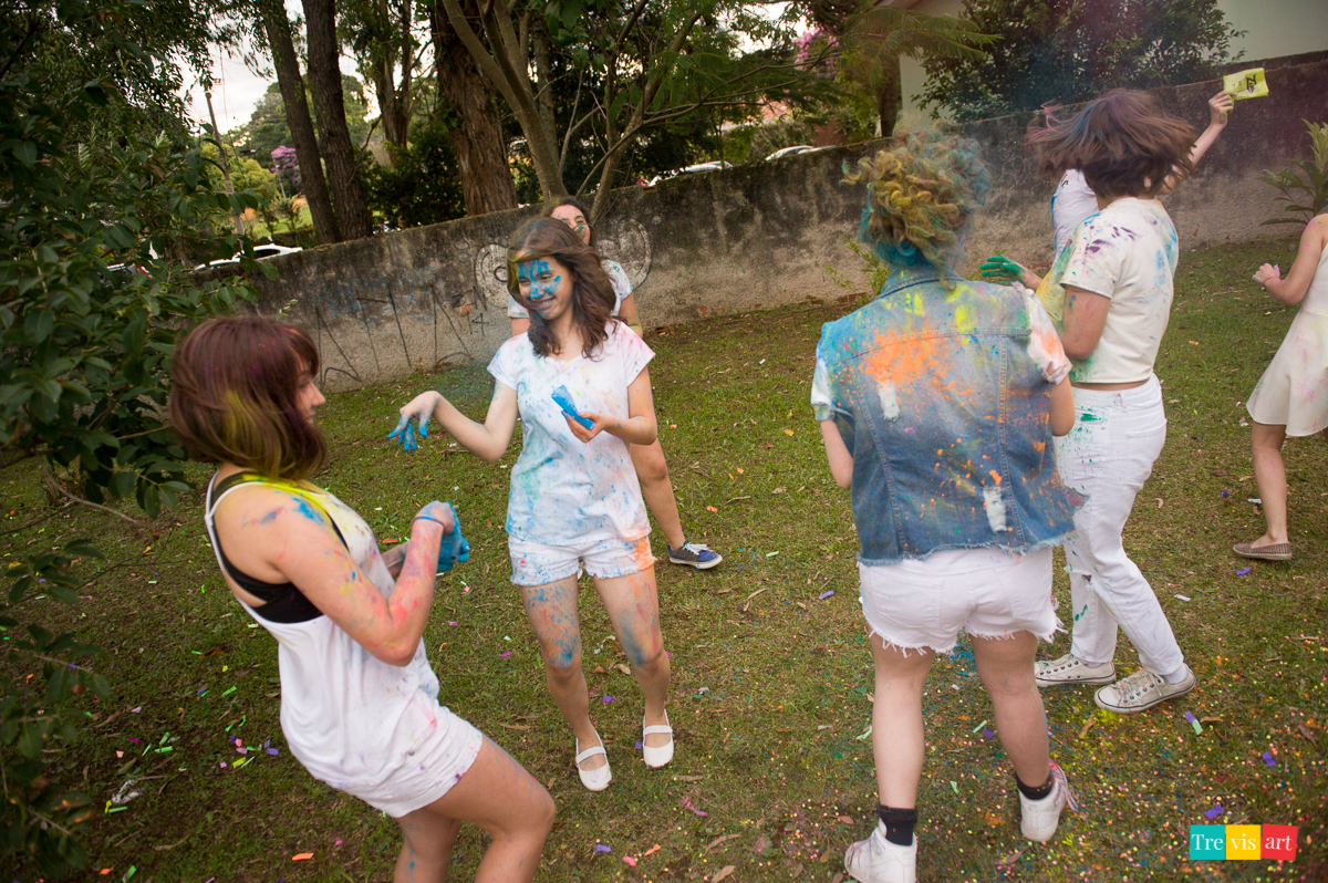 Meninas jogando e brincando com pó de happy holi colorido para fotografia de book de 15 anos da amiga