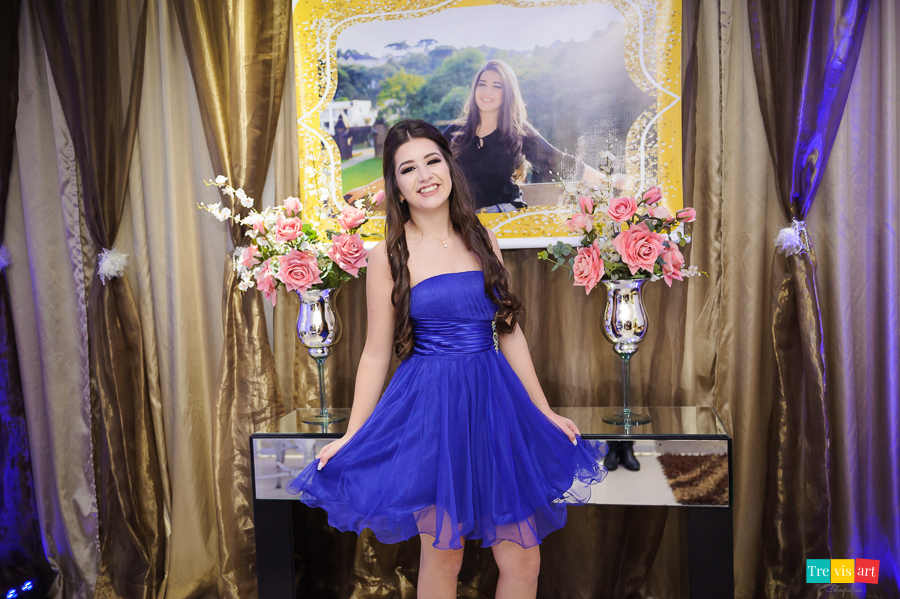 Aniversariante segurando vestido na foto no hall do salão de festa de 15 anos